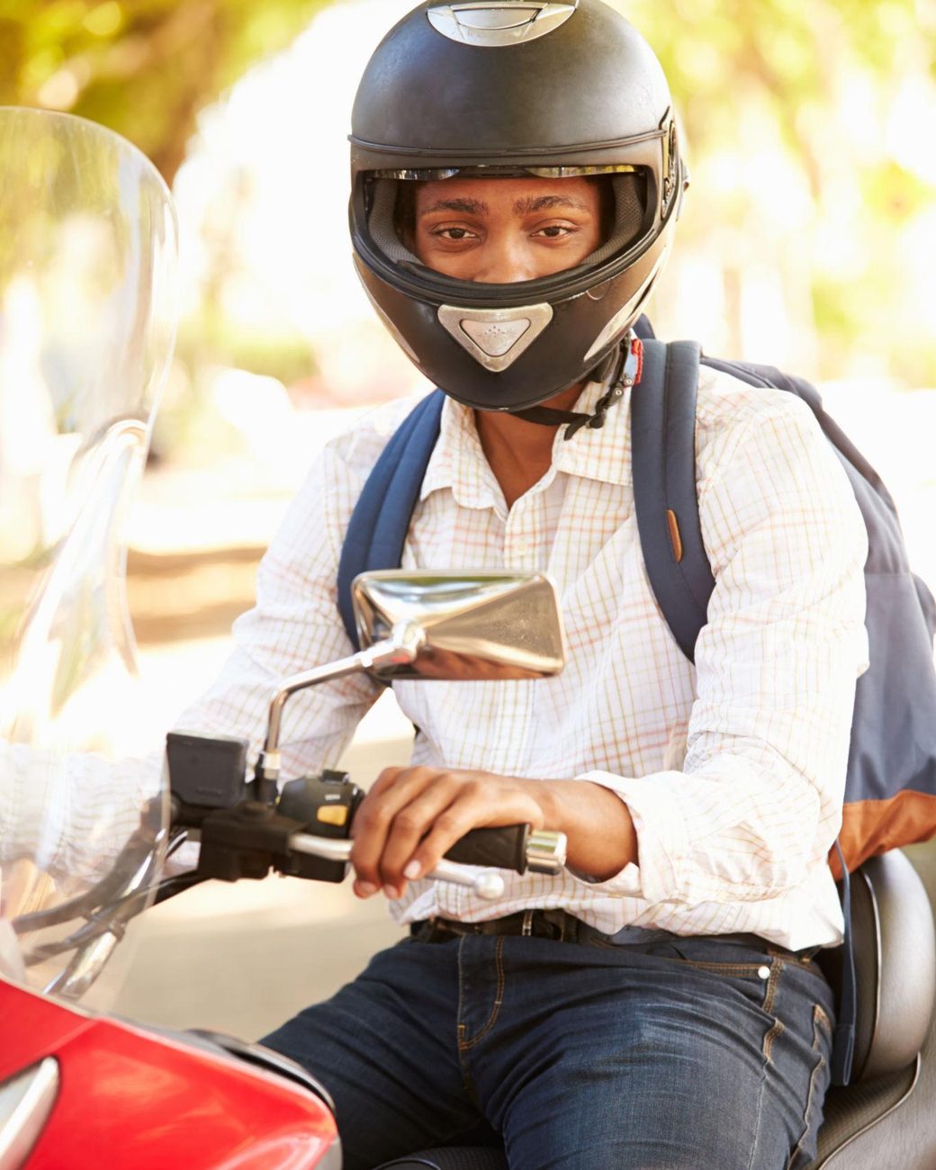 Motard portant un casque intégral au guidon de sa moto